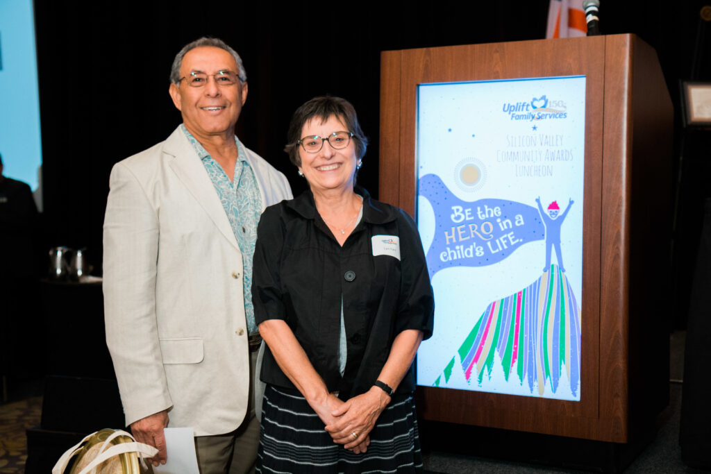 a man and a woman standing next to a sign