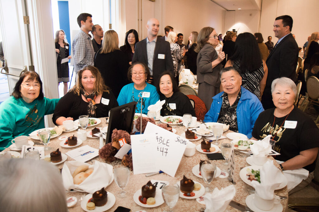 a group of people sitting at a table with food