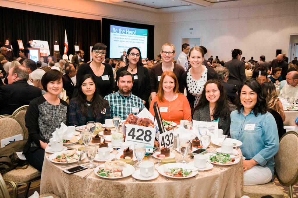 a group of people sitting at a table with food