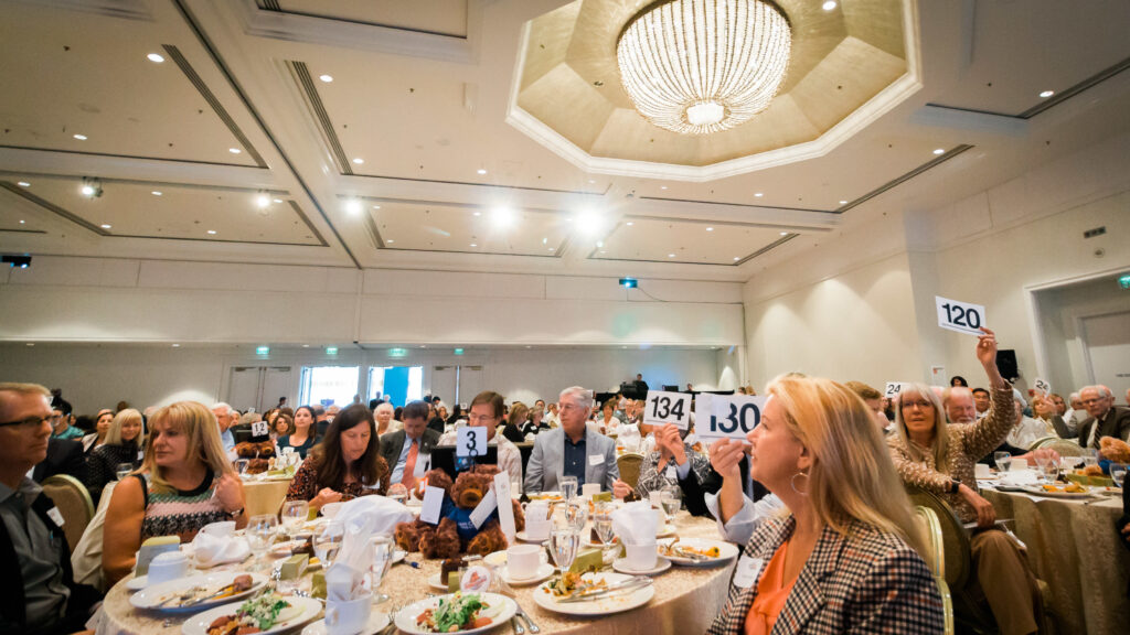 a large group of people sitting at tables eating food