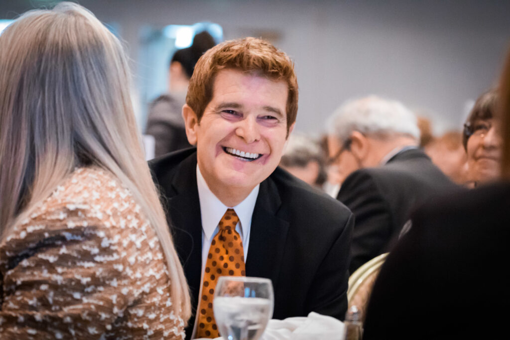 a man in a suit and tie smiling at a woman