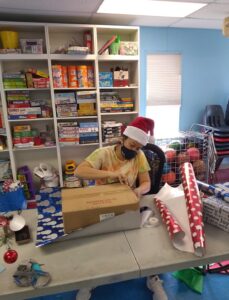 la holiday gift drive volunteer wrapping presents