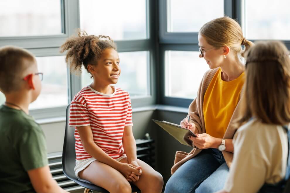 Women wearing yellow shirt teaching to children's