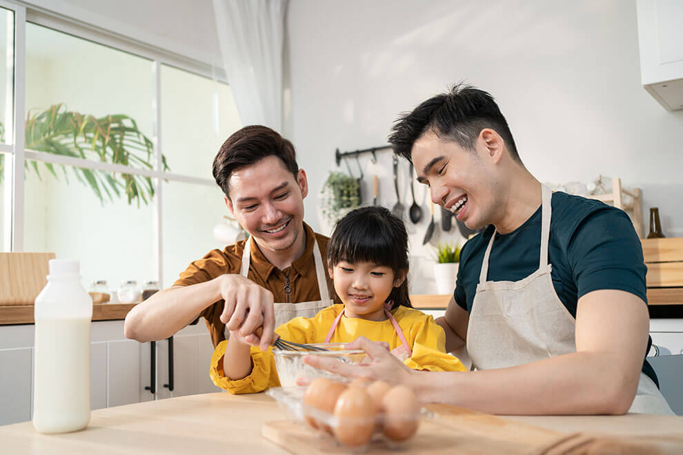 a same sex asian couple with their daughter