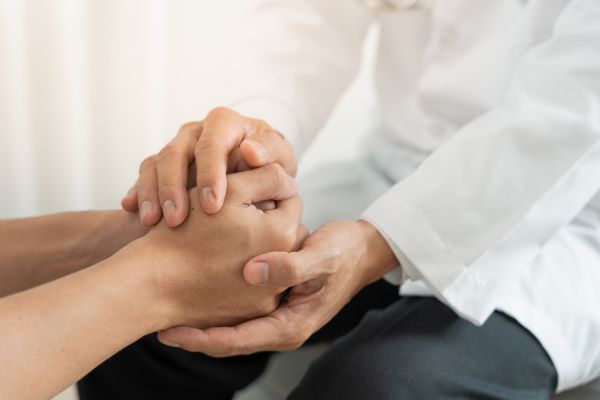 doctor holding a hand of an adult