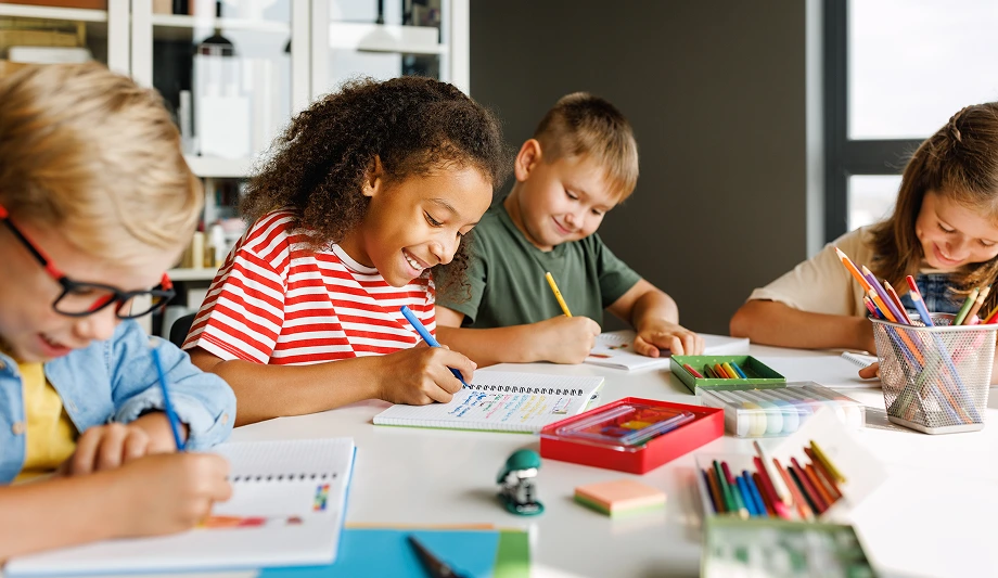 happy students coloring and doing crafts together