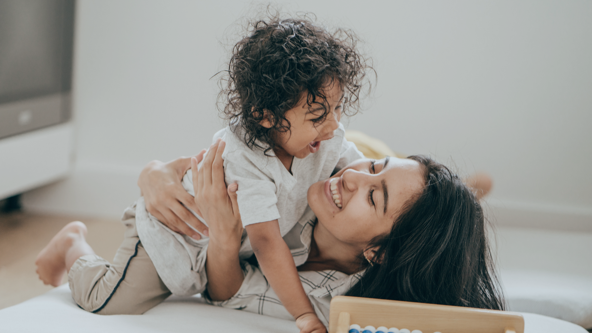 smiling mother and child playing - neuro-diversity affirming support and care
