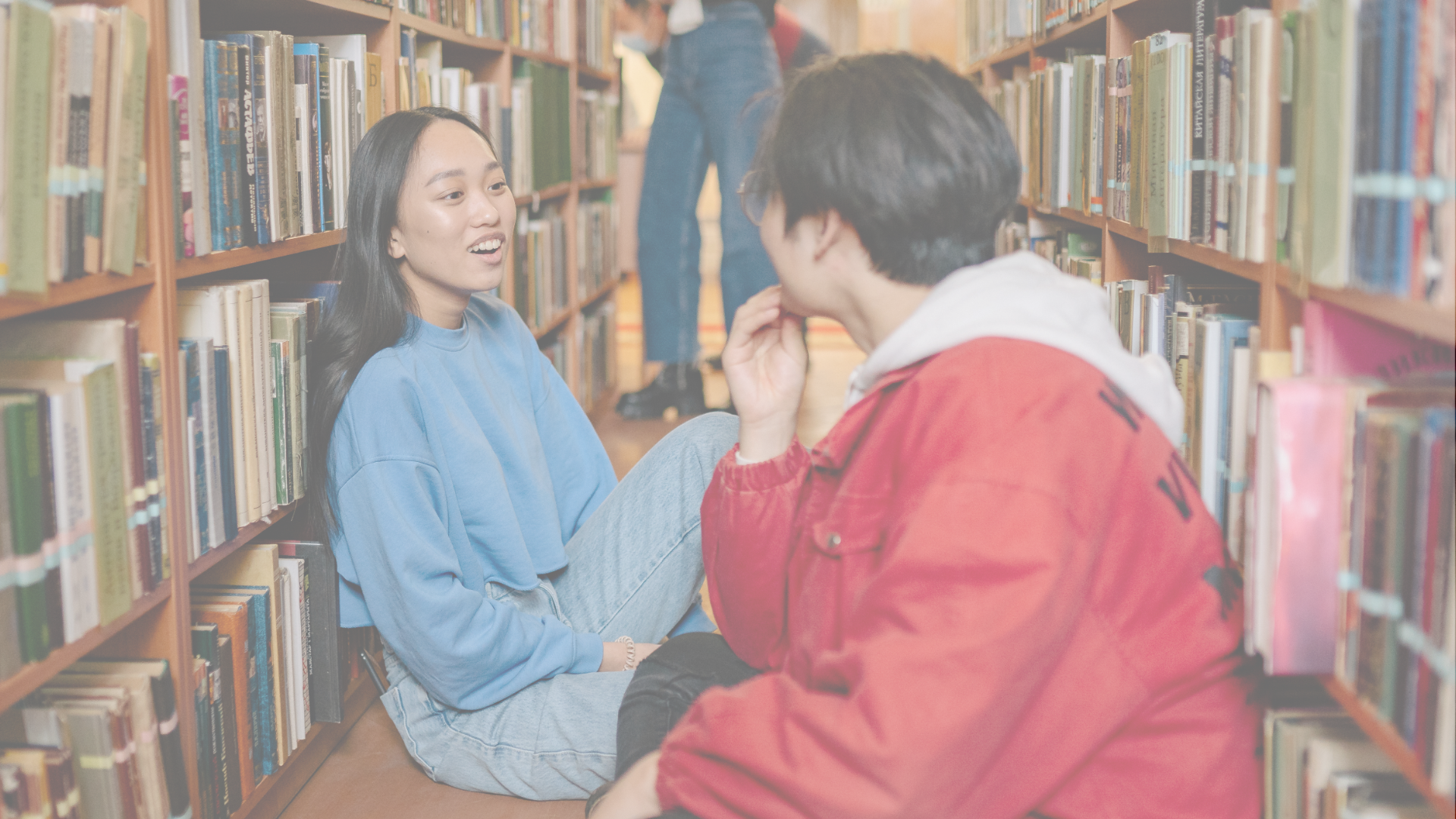 Asian American teen interacting with friend in a library